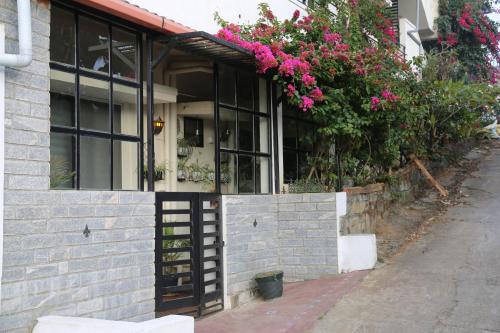 een huis met roze bloemen erop bij Tiny house for couple in Madikeri