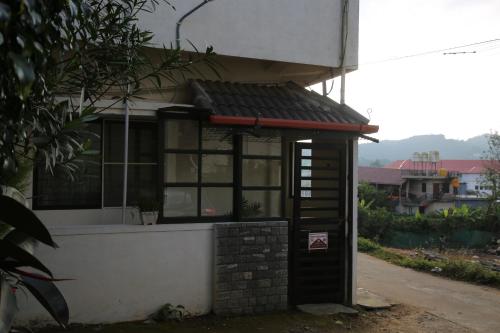 un pequeño edificio con un toldo rojo. en Cornwall for family, en Madikeri