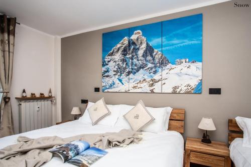 een slaapkamer met 2 bedden en een schilderij aan de muur bij Apartments Les Crouses in Valtournenche