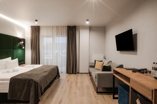 pokój hotelowy z łóżkiem i kanapą w obiekcie Premium Club SPA w mieście Bukowel