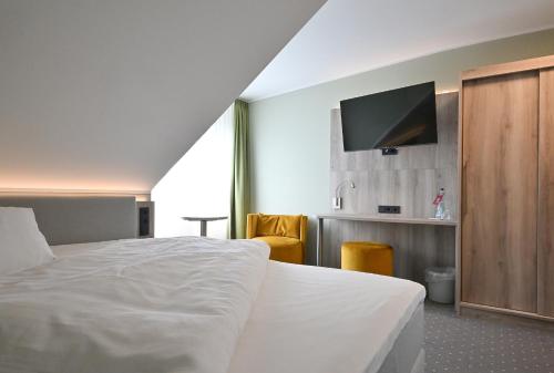 um quarto de hotel com uma cama e uma televisão de ecrã plano em Hotel Restaurant Zur Post Lohfelden em Kassel