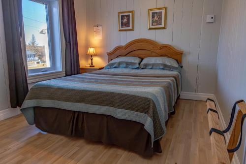 a bedroom with a large bed and a window at Gite la Maison Rochefort in Baie-Sainte-Catherine