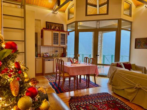 een woonkamer met een tafel en een kerstboom bij Villa Nano Kalavryta Βίλα στο βουνό με τζάκι κοντά στο χιονοδρομικό in Kalavrita