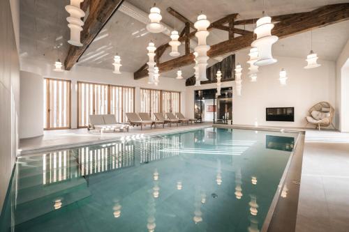 einen Innenpool mit blauem Wasser in einem Gebäude in der Unterkunft Posthotel Lamm in Sterzing