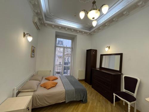 um quarto com uma cama, uma cómoda e uma televisão em Центрум Апартаментс em Lviv