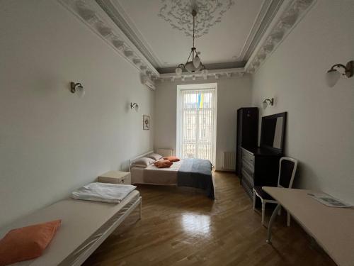 um quarto com uma cama, uma televisão e uma janela em Центрум Апартаментс em Lviv