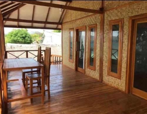 una veranda di una casa con tavolo e sedie di Gili Gede Homestay a Gili Gede