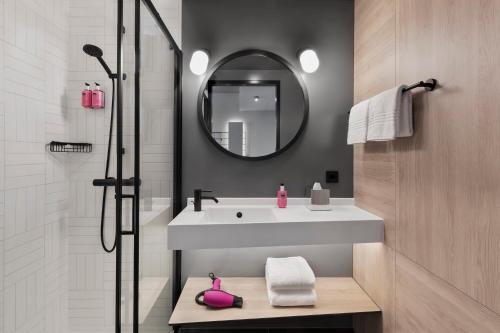 a bathroom with a sink and a mirror at Moxy Bremen in Bremen