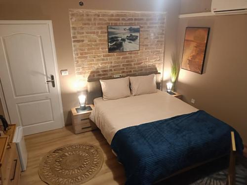 - une chambre avec un lit et un mur en briques dans l'établissement Hostel Anton, à Tivat