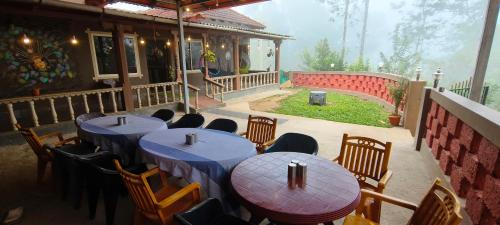 un restaurante con mesas y sillas azules y un porche en Horanadu Haranamakki Homestay, en Kalasa