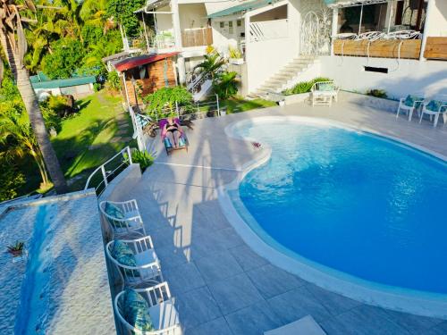 a swimming pool with chairs next to a house at Residence Ma Vie Là Ltee in Le Morne