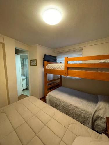 a bedroom with two bunk beds and a bathroom at Alojamientos en Torrealba, Recreo in Viña del Mar