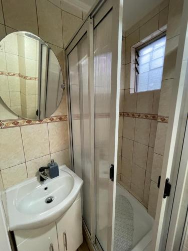 a bathroom with a sink and a shower and a mirror at Alojamientos en Torrealba, Recreo in Viña del Mar