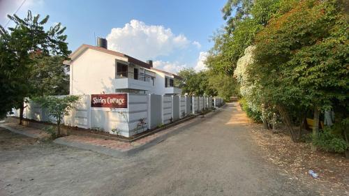 un edificio blanco con un cartel en el costado en shirley cottage, en Daulatābād