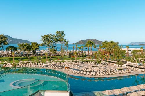 uma vista para um resort com uma piscina e cadeiras em Liberty Signa em Oludeniz