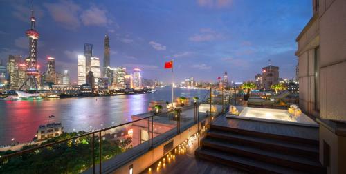 Blick auf einen Fluss und eine Stadt in der Nacht in der Unterkunft The Peninsula Shanghai in Shanghai