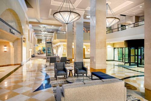 un hall avec des chaises et des tables dans un bâtiment dans l'établissement Sheraton Pentagon City, à Arlington