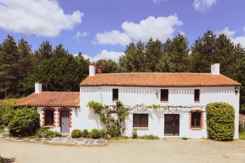 een wit huis met een rood dak bij Nature et partage - Gîte tout équipé in Grand-Landes