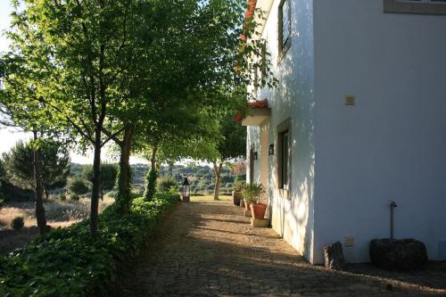 een pad naast een wit gebouw met bomen bij Casa do Campo - Castelo Branco in Castelo Branco