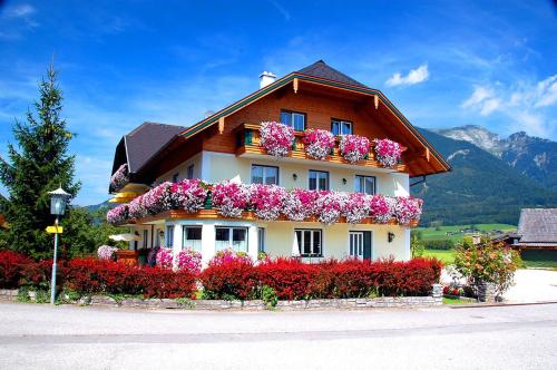 une maison avec des fleurs sur son côté dans l'établissement Gästehaus Kloibergütl, à Sankt Gilgen