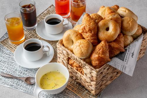 uma cesta de produtos de pastelaria e chávenas de café e sumo de laranja em HOTEL Mai Sakura em Nara