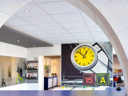 un grande orologio su un muro in un negozio di ibis Styles Vannes Gare Centre a Vannes