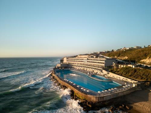 ein Schwimmbad am Strand neben dem Meer in der Unterkunft Arribas Sintra Hotel in Sintra