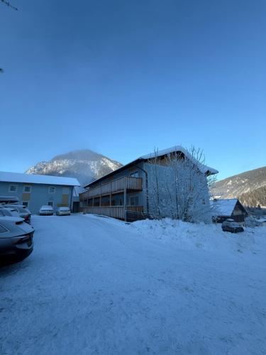 a building in the snow with cars parked in front at Zeffererhof in Schladming