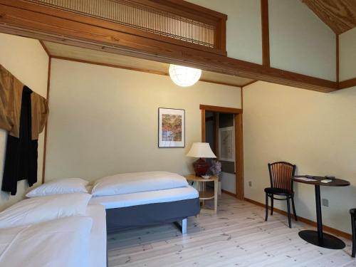 - une chambre avec un lit, une table et une chaise dans l'établissement Den Japanske Have B & B, à Herning