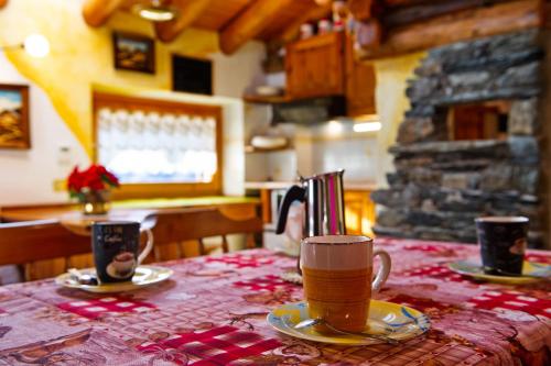 a table with two cups of coffee on top of it at Chalet L'Ange Des Neiges in Valtournenche