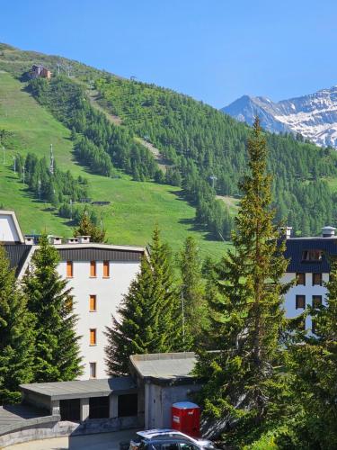 uma vista para uma montanha com um edifício e árvores em Moda Apartments 69 em Sestriere