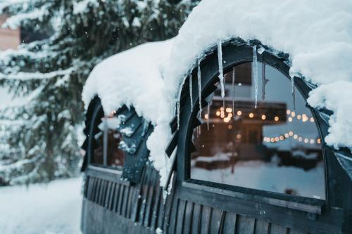 uma cerca coberta de neve com luzes na janela em Flem Mountain Lodge em Flims