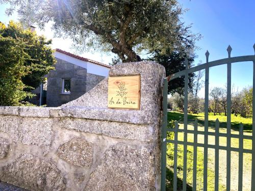 une clôture en pierre avec un panneau au-dessus dans l'établissement Ar da Beira, à Belmonte