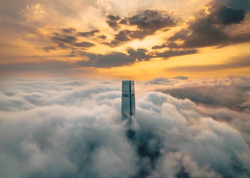 een wolkenkrabber midden in een zee van wolken bij The Ritz-Carlton, Hong Kong in Hong Kong