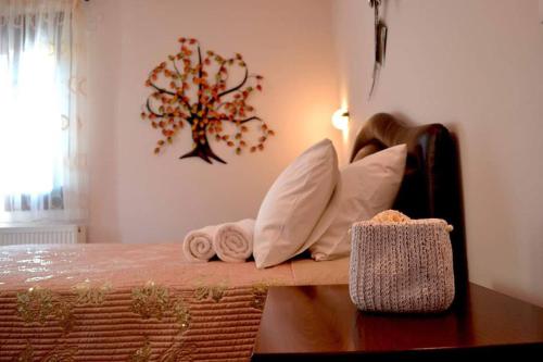 Habitación con cama con almohadas y árbol en la pared. en Anesis, en Ioannina