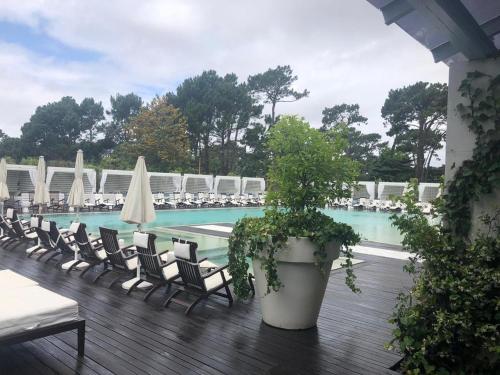 una piscina con sillas y una maceta en una terraza en Yoo Punta Del Este, en Punta del Este