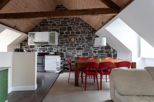 eine Küche und ein Esszimmer mit einem Tisch und roten Stühlen in der Unterkunft Hotel Champlain in Québec