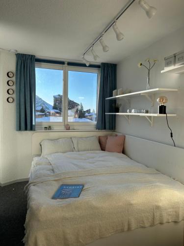 een slaapkamer met een groot bed en een raam bij Hygge Ski-in-Ski-out med udsigt in Avoriaz