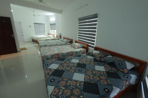 Cette chambre dispose de 3 lits et d'un échiquier. dans l'établissement Kailasam Residency, à Trivandrum