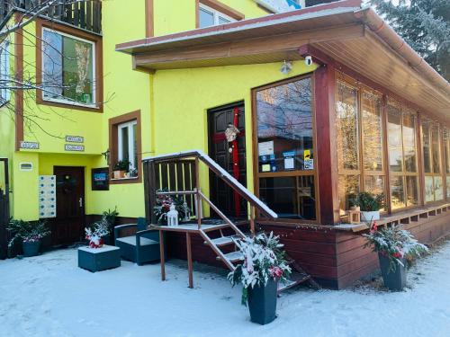 ein gelbes Gebäude mit einer Treppe im Schnee in der Unterkunft Pension Aqualand Free parking in Poprad