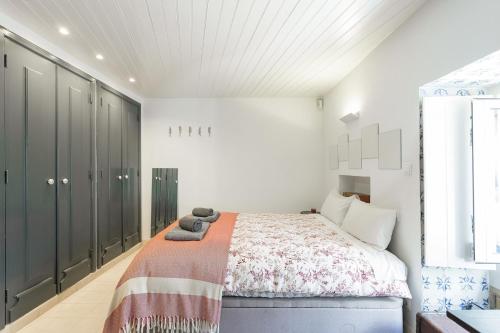 una camera da letto con un letto coperto di Principe Real Swoonworthy, Pristine, 1BR Cottage a Lisbona