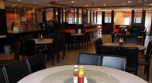 a dining room with tables and chairs in a restaurant at Grand City Hotel in Bandar Seri Begawan