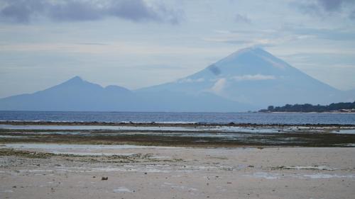 een berg in de verte met een strand en water bij Mola2 Resort Gili Air in Gili Air