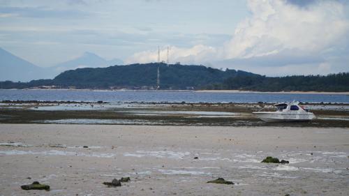 een boot aan de kust van een strand bij Mola2 Resort Gili Air in Gili Air