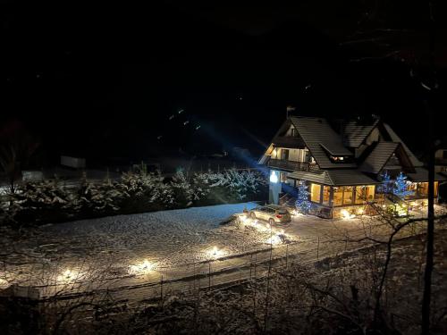 Una casa iluminada por la noche con luces de Navidad en Willa FOLK Pieniny, en Szczawnica