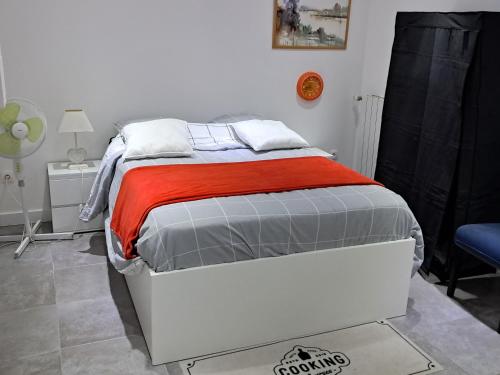 een slaapkamer met een wit bed en een rode deken bij Appartement de vacances in Illkirch-Graffenstaden