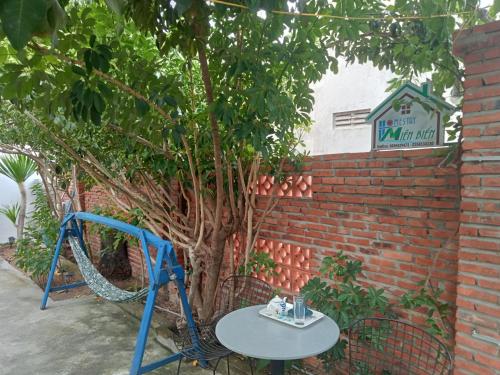 una mesa junto a un árbol con un columpio en Homestay Miền Biển Vĩnh Hy 2, en Vĩnh Hy