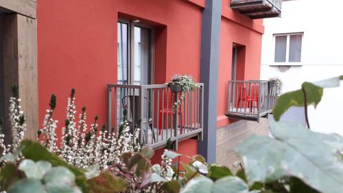 un edificio rojo con un balcón con flores. en B&B Corte Rossa, en Tirano