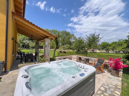 una bañera de hidromasaje en el patio trasero de una casa en Natura Bungalows, en Limenas