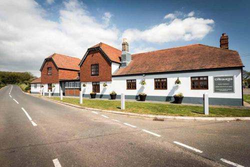 um edifício ao lado de uma estrada em The Chequers Inn em Rookley